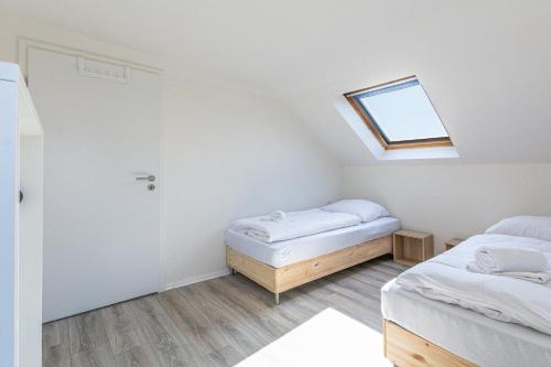 a bedroom with two beds and a skylight at T&K Apartments Wegberg 5 Monteur Apartments in Wegberg