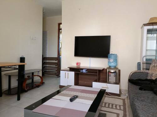 a living room with a flat screen tv on a wall at Tashie homes in Machakos