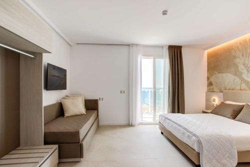 a bedroom with a bed and a couch at Hotel Mirafiori in Lido di Jesolo