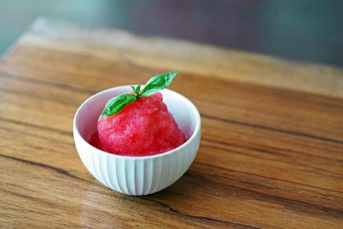 a white bowl with a strawberry in it on a wooden table at Casa Cayuco Eco-Adventure Lodge in Bocas del Toro