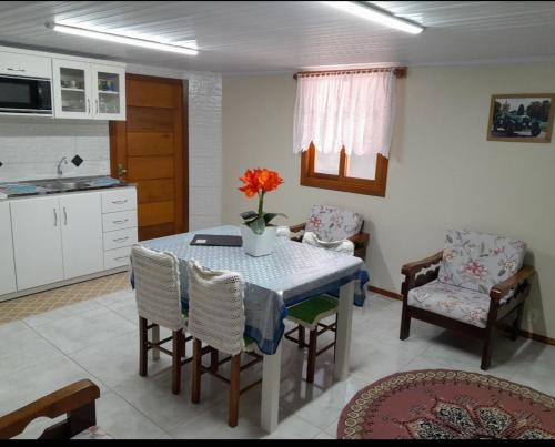 a kitchen and dining room with a table and chairs at Casa e Flat Conforto Gramado in Gramado