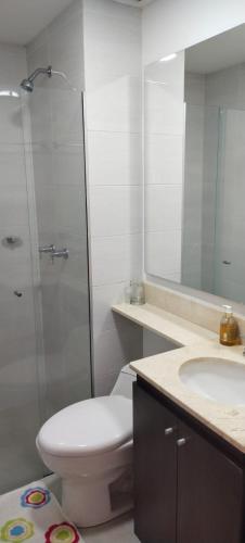 y baño con aseo, lavabo y espejo. en Habitación en apartamento familiar en Medellín