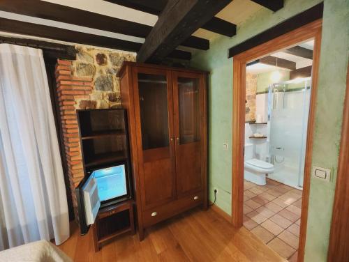 a living room with a tv and a bathroom at Posada el Remanso de Trivieco in La Cavada