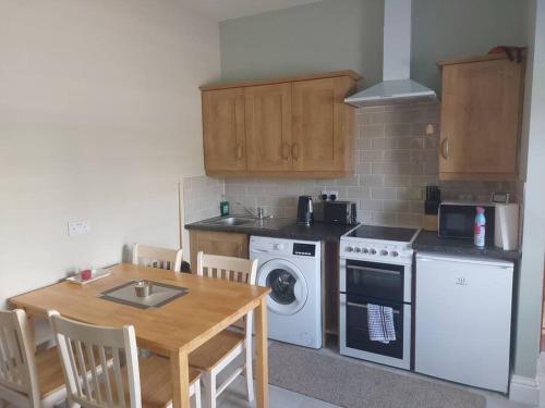 a kitchen with a table and a stove and a dishwasher at Castle Chalets in Cork