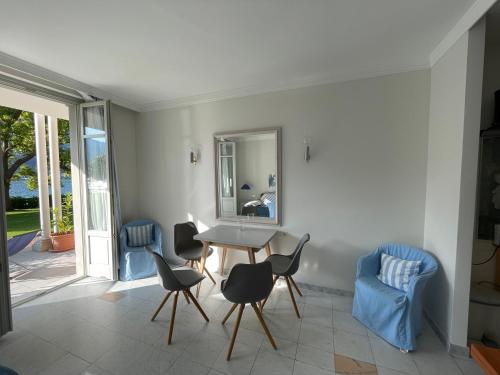 a dining room with a table and chairs and a mirror at Ville Lago Lugano in Porto Ceresio