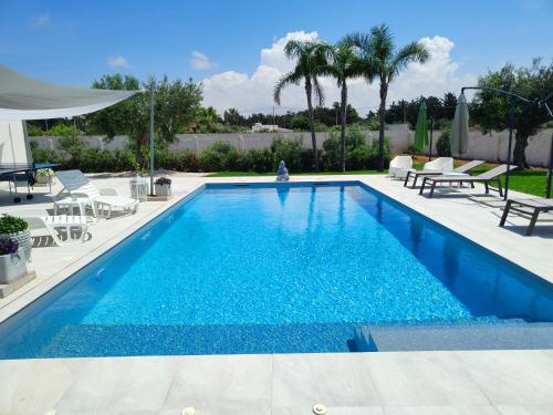 a swimming pool with blue water in a yard at Suite12 in Marsala
