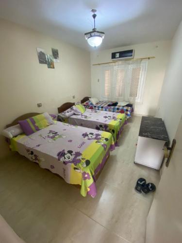 eine Gruppe von 3 Betten in einem Zimmer in der Unterkunft فيلا مكيفة بجاردن ورووف بالنجيل الصناعى وبرجولا in Dawwār ‘Abd Allāh