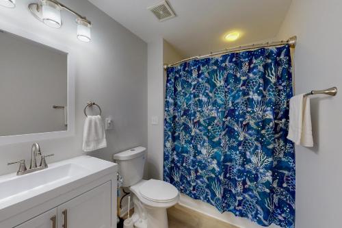 a bathroom with a blue shower curtain and a toilet at Tuna #21A-CAC in Buxton