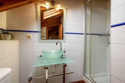 a bathroom with a glass sink and a shower at Romántico acogedor apartamento en Llanes (Montaña) in Llanes