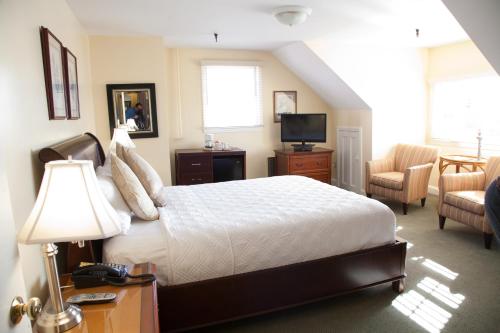 a bedroom with a bed and a living room at The Inn at Longshore in Westport