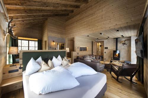 ein Schlafzimmer mit einem großen Bett und ein Wohnzimmer in der Unterkunft Alphotel Tyrol in Ratschings