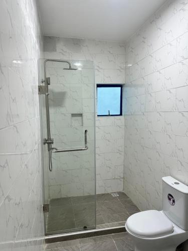 a bathroom with a shower with a toilet and a window at Maxx Msquare Hotel in Agege