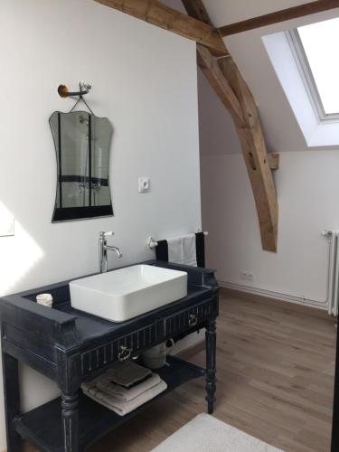 a bathroom with a white sink on a black table at 2 DESCARTES in La Flèche