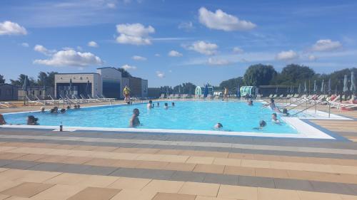 a group of people swimming in a swimming pool at CALDERA LUXURY LODGE in Tattershall