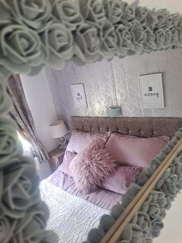 a bedroom with a bed with pink pillows at CALDERA LUXURY LODGE in Tattershall