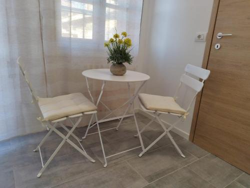 a table and two chairs with a vase of flowers on it at b&b Casa Balai 72 a 150 mt dal mare in Porto Torres
