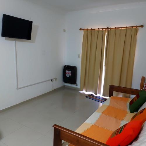 a room with a bed and a flat screen tv at Edificio Mirasol 3 in Federación