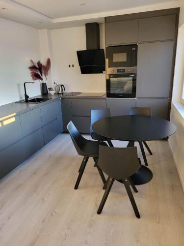 a kitchen with a black table and chairs in a room at Apartment nearby sentrum in Bergen