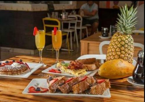 a table with two plates of food and a pineapple at STARFISH LUXURY APARTMENT in San Juan