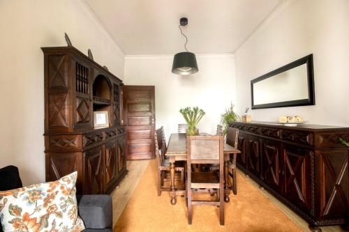 ein Esszimmer mit einem Tisch und Holzmöbeln in der Unterkunft Apartamento do Arquinho I - by VinteOito in Amarante