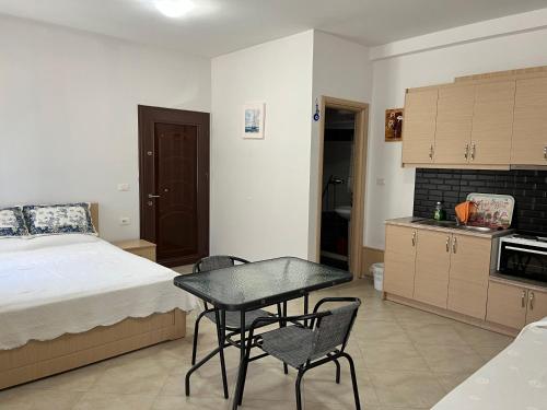 1 dormitorio con 1 cama, mesa y sillas en Korali apartment, en Sarandë