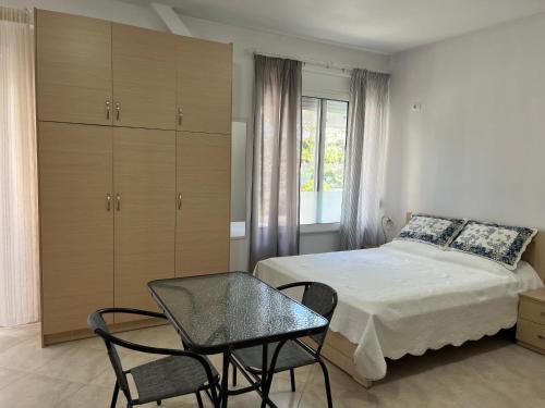 1 dormitorio con 1 cama, 1 mesa y 1 silla en Korali apartment, en Sarandë