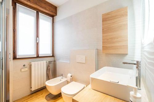 a white bathroom with a sink and a toilet at Casa Vacanze Salirai in Ponte in Valtellina