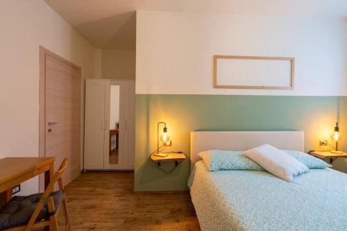a bedroom with a bed and a table and a desk at Casa Vacanze Salirai in Ponte in Valtellina