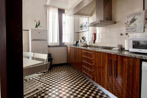 a kitchen with a black and white checkered floor at Apartamento do Arquinho I - by VinteOito in Amarante