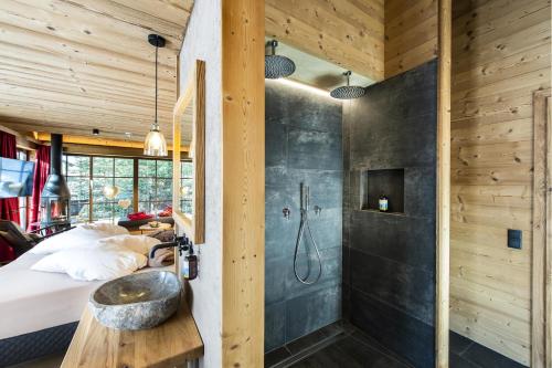 a bedroom with a shower and a bed with a sink at Alphotel Tyrol in Racines
