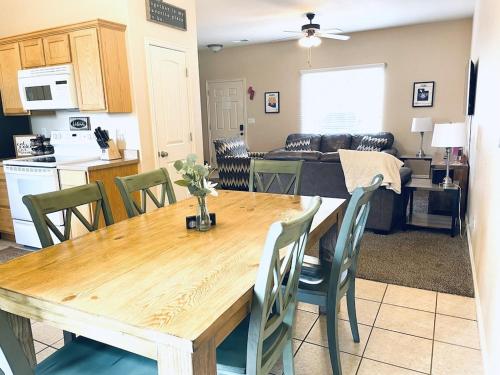a kitchen and living room with a wooden table and chairs at 3BR / 2BA Townhome with Pool, Patio, WiFi, Washer/Dryer in Kanab