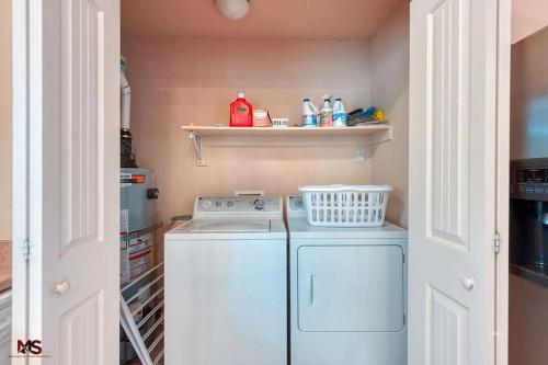 a small kitchen with a washing machine and a shelf at 3BR / 2BA Townhome with Pool, Patio, WiFi, Washer/Dryer in Kanab