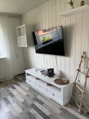 een woonkamer met een tv aan de muur bij Ferienwohnung in Bremerhaven in Bremerhaven