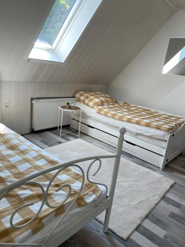een slaapkamer op zolder met 2 bedden en een raam bij Ferienwohnung in Bremerhaven in Bremerhaven