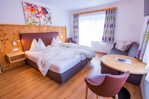 ein Schlafzimmer mit einem Bett, einem Tisch und einem Stuhl in der Unterkunft Bergerhof in Ramsau am Dachstein
