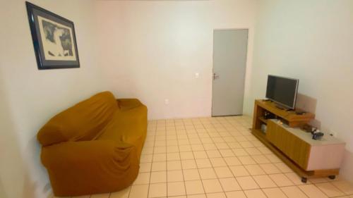 a living room with a yellow couch and a television at Shangrila 2 in Maceió