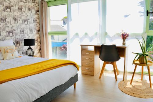 a bedroom with a bed and a desk and a chair at Appartement lumineux entre Mer et Campagne in Pordic