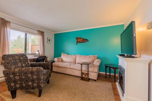 a living room with a couch and a flat screen tv at The Cabins at Alert Bay in Alert Bay