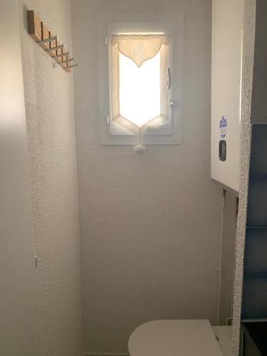 a small bathroom with a toilet and a window at Mon Petit Paradis, vue sur dunes et mer, accès direct plage Robinson, terrasse, WIFI, parking privé, très ressourçant, à Marseillan Plage in Marseillan