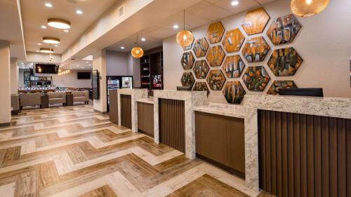 a lobby of a restaurant with a bar with wooden floors at Hotel Manhattan, BW Signature Collection in New Caney