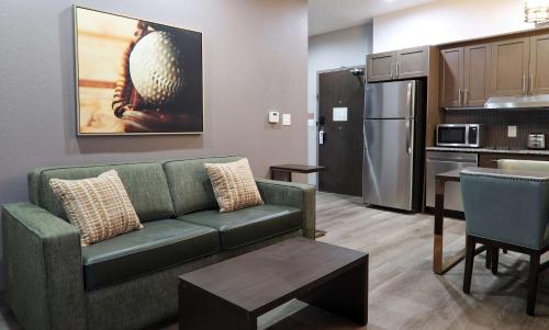 a living room with a couch and a kitchen at Hotel Manhattan, BW Signature Collection in New Caney