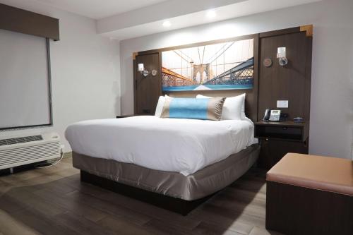 a hotel room with a large bed and a flat screen tv at Hotel Manhattan, BW Signature Collection in New Caney