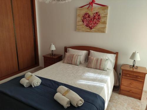 a bedroom with a bed with two pillows on it at Apartamento- csantos in Olhos de Água