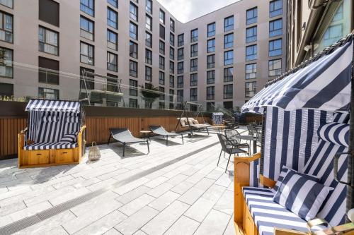 patio z krzesłami, stołami i budynkami w obiekcie Radisson Hotel & Suites Zurich w mieście Opfikon