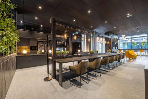 a long table in a room with yellow chairs at Radisson Hotel & Suites Zurich in Opfikon