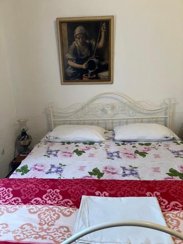 a bed in a bedroom with a picture on the wall at Somborski salas - strogi centar in Sombor