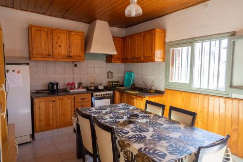 una cocina con armarios de madera y una mesa con sillas. en Casa San Rafael en San Rafael