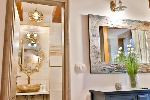 W łazience znajduje się lustro i umywalka. w obiekcie Royal Suite Mia w mieście Piran