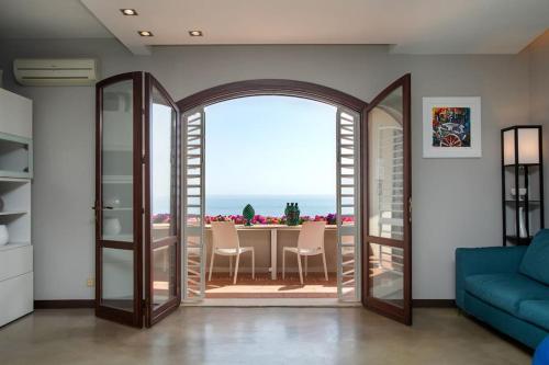ein Wohnzimmer mit einer Glastür, die auf eine Terrasse führt in der Unterkunft [Mare privato] Villa Casamare in Acireale