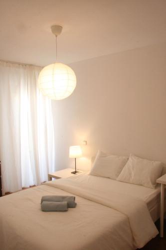 a bedroom with a large white bed with a light fixture at Campo Grande Residence in Lisbon